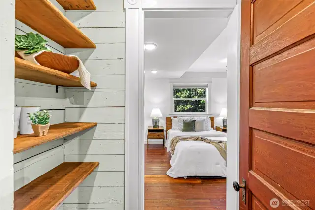 Entry to the main floor primary. Original wood stair treads repurposed into built-in shelving