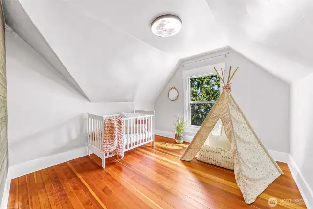 Upstairs bedroom number 2 with charming ceiling angles and a beautiful southern view of the fruit trees.