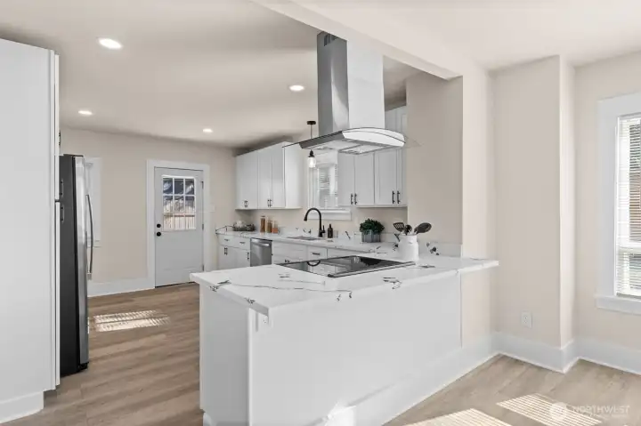 Stunning, completely remodeled kitchen with quartz counters, stainless appliances, opens to dining and living