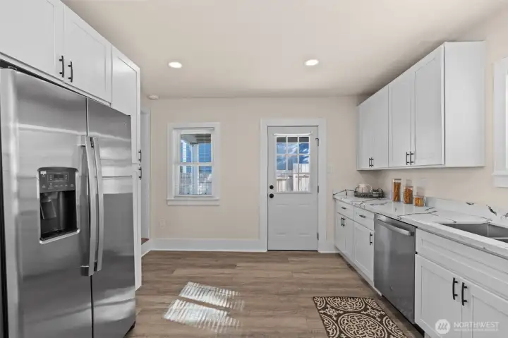 Kitchen door leads to patio and huge, fully fenced yard