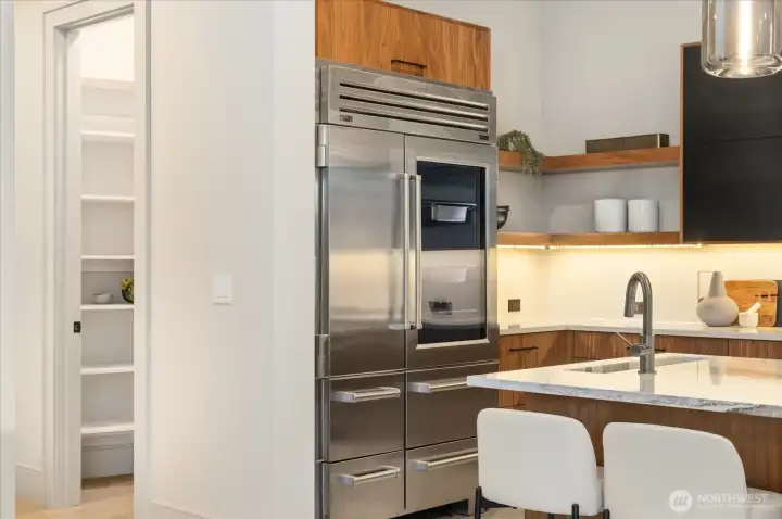 Subzero glass front doors and pull out drawers on this Refrigerator. Floating shelves for display and storage