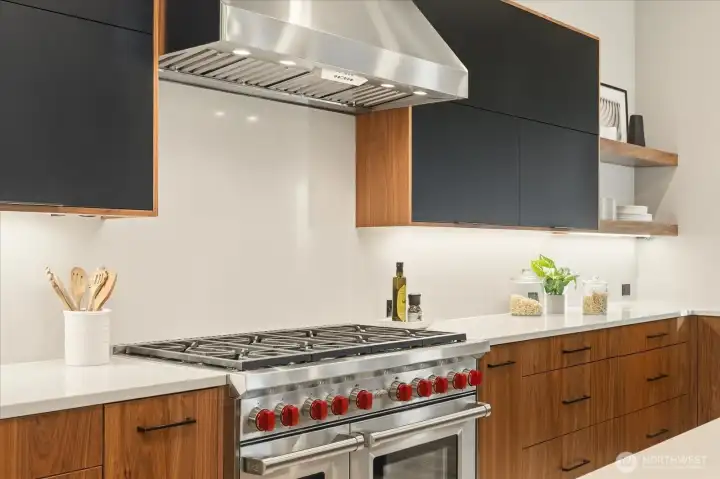 8-burner Wolf gas range and two ovens with full slab backsplash