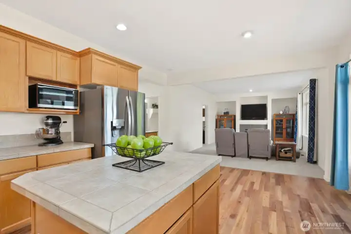 Kitchen with beautifully refinished solid hardwood floors & family room.  Refrigerator / freezer, microwave, dishwasher, and stove convey with sale.