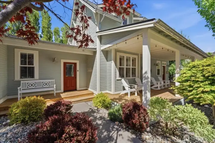 Exterior view of home with classic covered front porch and mature landscaping.