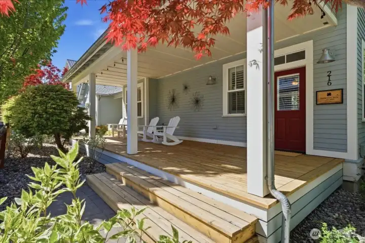 Exterior view of classic covered front porch with Adirondack chairs.