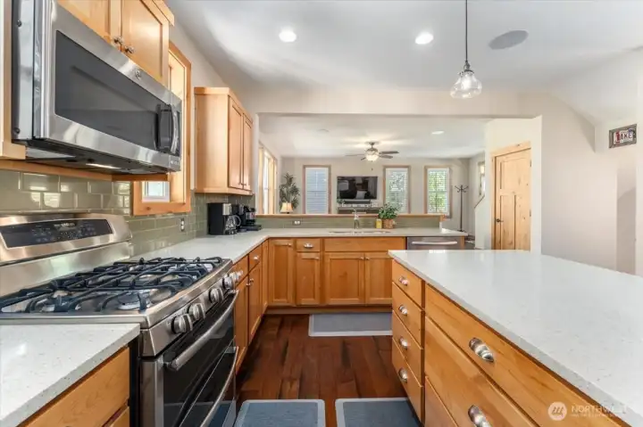 View 1 of kitchen with quartz countertops and stainless steel appliances.