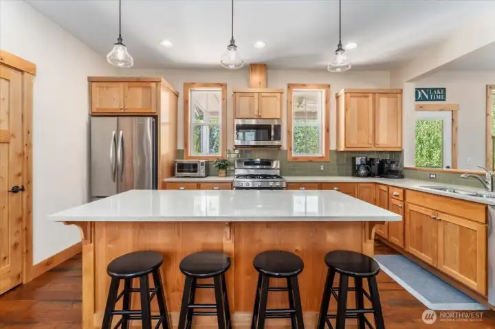 View 3 of kitchen with quartz countertops and stainless steel appliances and sit up bar.