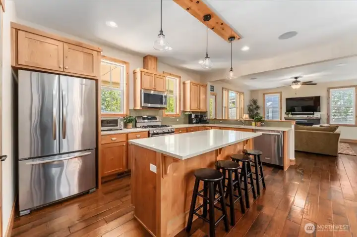 View 4 of kitchen with quartz countertops and stainless steel appliances and sit up bar.