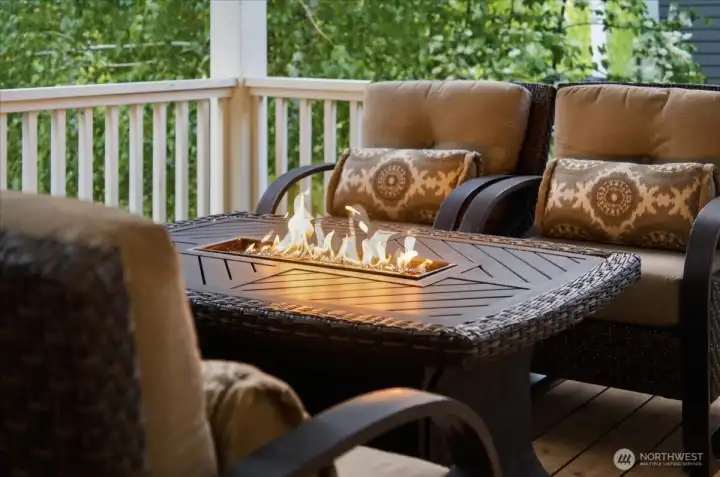 View of outdoor living area with lake views and lounge area with fire table.