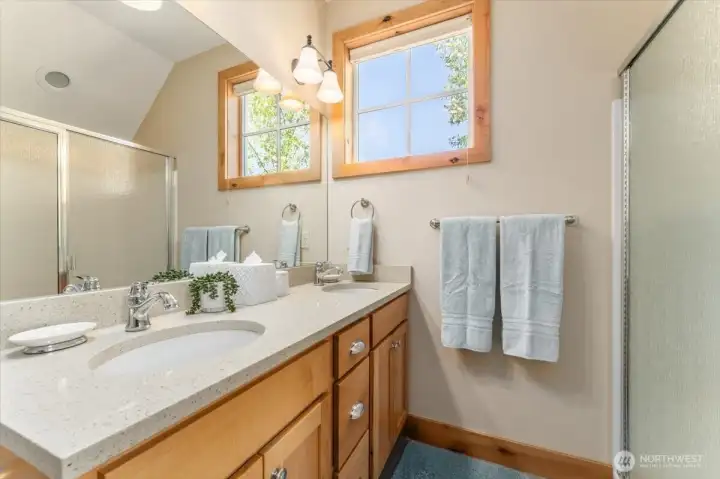 View 1 of upper level Primary Bedroom full bathroom with quartz countertops.