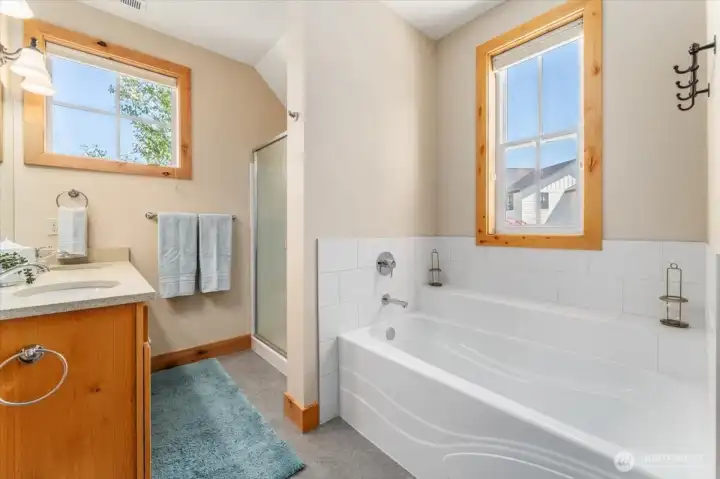 View 2 of upper level Primary Bedroom full bathroom with quartz countertops and separate bathtub.
