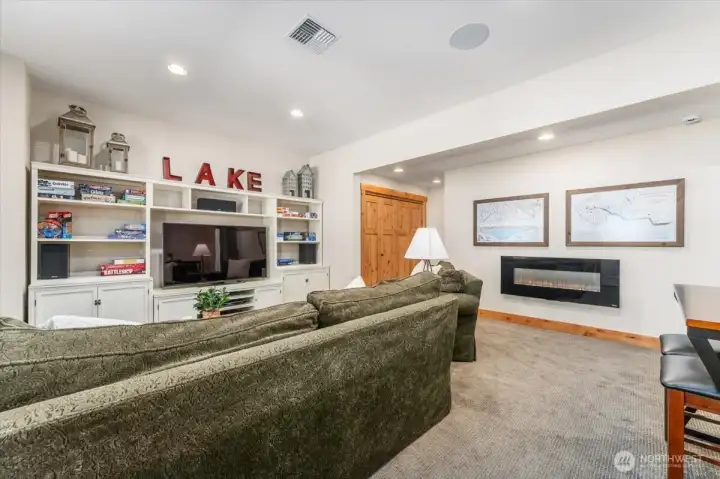 View 2 of lower level bonus/media room with electric fireplace.