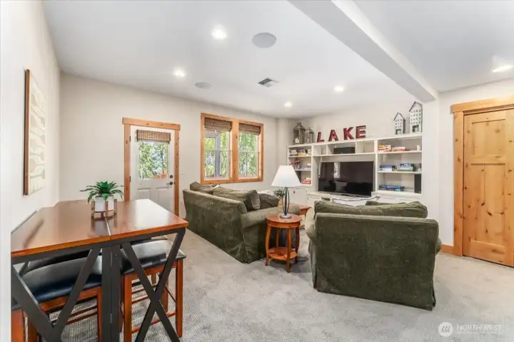 View 3 of lower level bonus/media room with doors leading out to the lower level outdoor living area.