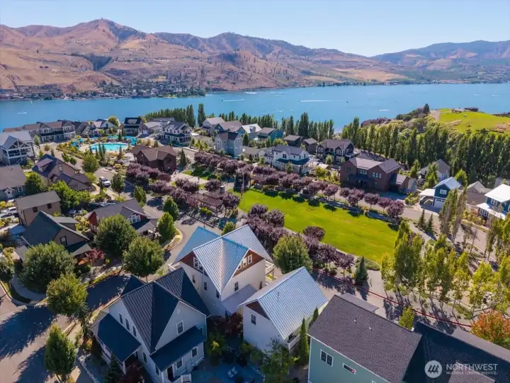 Aerial view of The Lookout's Hilltop Park with grassy area, playground, pickleball court, clubhouse, pool and hot tub.