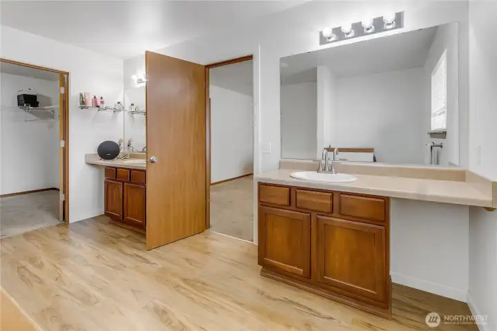 Primary ensuite bathroom with dual vanities, soaking tub, and walk-in shower.