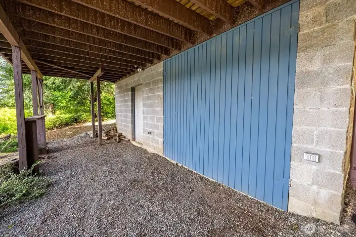 Additional outdoor space under deck with large sliding door leading to storage.