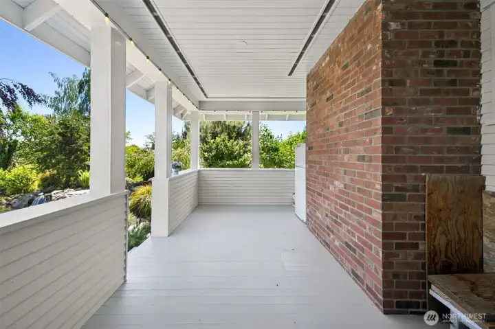 Covered outdoor space off kitchen eating space. Stairs go down to pond/waterfall/patio space.