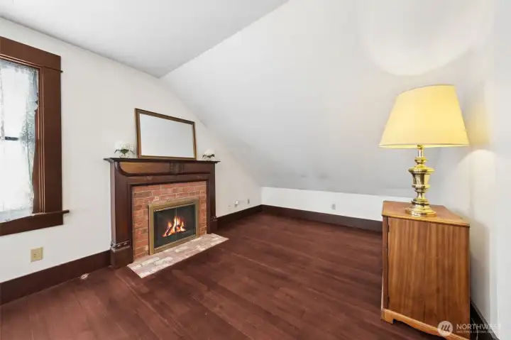 Master bedroom seating area with wood fireplace.