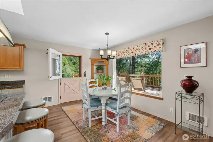 Enjoy meals with a view in the dining area, featuring a charming Dutch door that opens to the surrounding landscape. Enjoy meals with a view in the dining area, featuring a charming Dutch door that opens to the surrounding landscape.