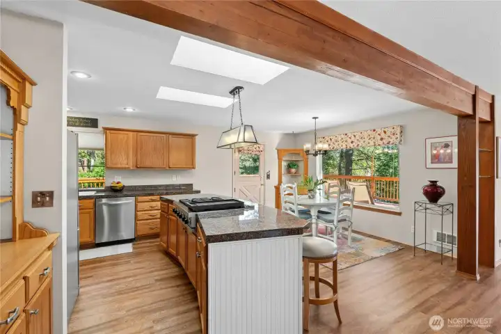 A stunning center island, exposed beam, and open-concept design connect the kitchen and dining spaces with timeless Northwest character. A stunning center island, exposed beam, and open-concept design connect the kitchen and dining spaces with timeless Northwest character.