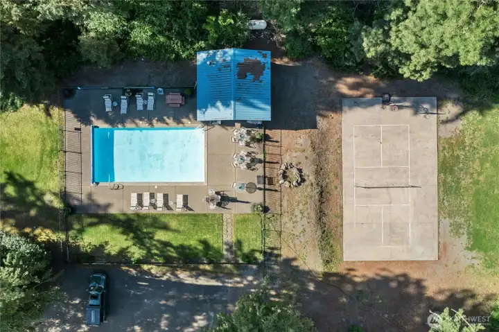 An aerial perspective showcases the pool, pool house, and adjacent sport court, highlighting the property's incredible recreational amenities. An aerial perspective showcases the pool, pool house, and adjacent sport court, highlighting the property's incredible recreational amenities.