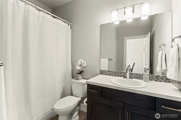 Full bathroom featuring a single-sink vanity, tub/shower combination, and contemporary finishes. Full bathroom featuring a single-sink vanity, tub/shower combination, and contemporary finishes.