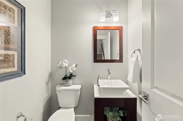 Convenient main-level powder room features a contemporary vessel sink vanity and modern finishes. Convenient main-level powder room features a contemporary vessel sink vanity and modern finishes.