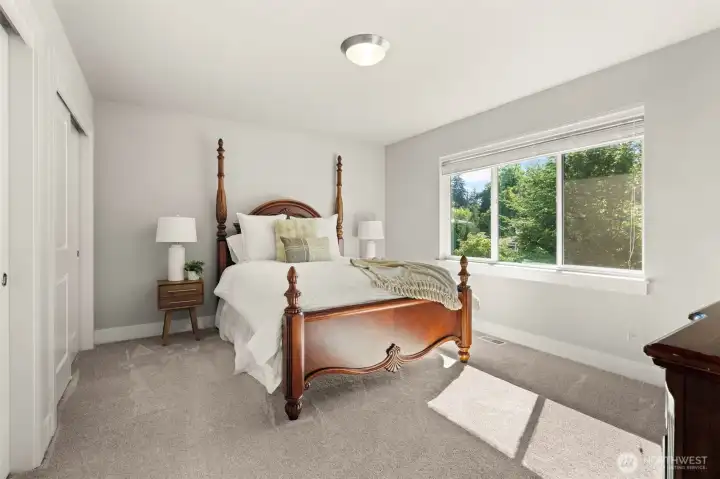 Comfortable bedroom features a spacious layout, a large picture window, and peaceful views of the surrounding greenery. Comfortable bedroom features a spacious layout, a large picture window, and peaceful views of the surrounding greenery.