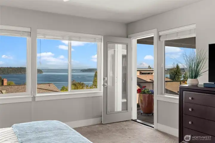 Large picture windows frame sweeping water views, while a private door opens to the covered deck. Large picture windows frame sweeping water views, while a private door opens to the covered deck.
