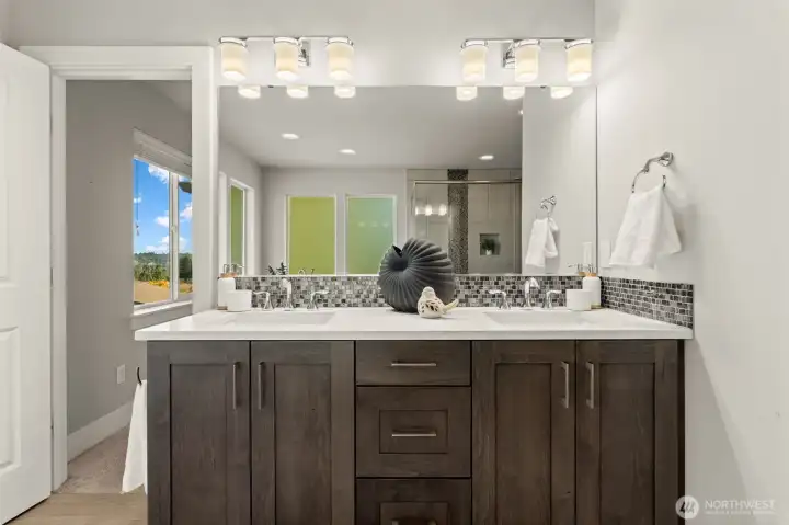 The primary bathroom features a dual-sink vanity with generous cabinet storage and an expansive mirror. The primary bathroom features a dual-sink vanity with generous cabinet storage and an expansive mirror.