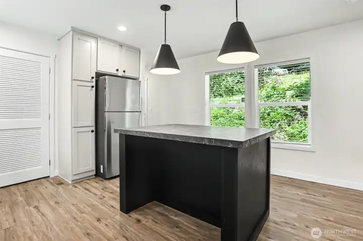 Kitchen space with plenty of natural light and laundry room door to the left Kitchen space with plenty of natural light and laundry room door to the left