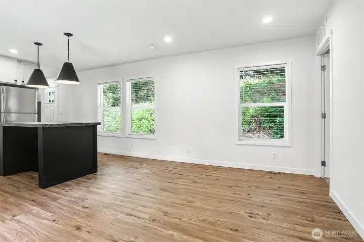 Living space adjacent to the kitchen. Front door is on the left of the photo and door leading to primary bedroom is on the right Living space adjacent to the kitchen. Front door is on the left of the photo and door leading to primary bedroom is on the right