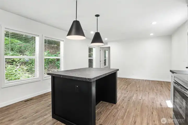 Spacious kitchen with a large island, opening to the primary bedroom entrance beyond. Spacious kitchen with a large island, opening to the primary bedroom entrance beyond.