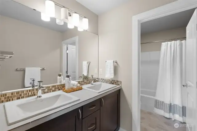 The shared full bathroom exudes both functionality and elegance with its thoughtful design and luxurious features. It offers the inclusion of dual vanities ensuring ample space for multiple users, allowing for a seamless and convenient morning routine.