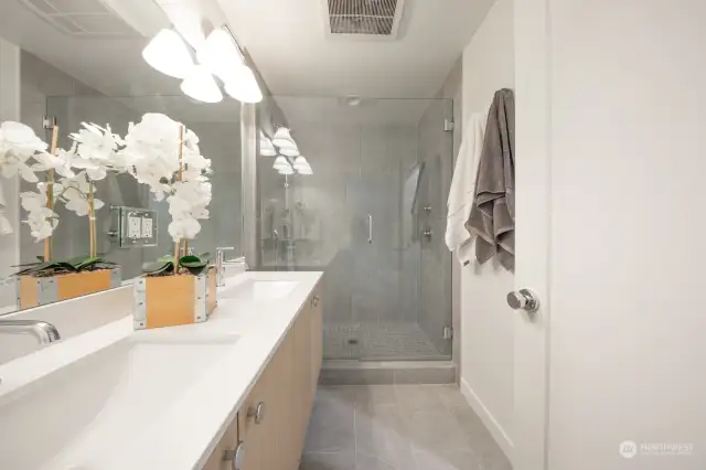 Prime bath with large walk in shower and double vanity with quartz slab countertop