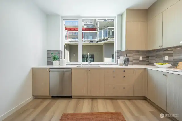 Large kitchen with tile backsplash, Luxury vinyl flooring and custom cabinets