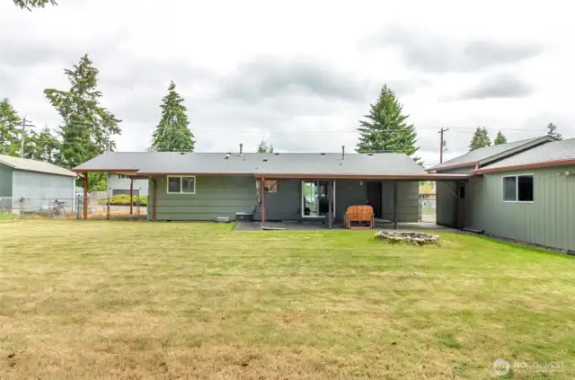 Back of the house view with garage and view of the carport.