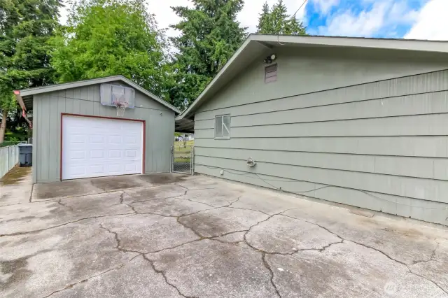 480 sq ft detached garage with mounted basketball hoop and plenty of concrete work for playing.