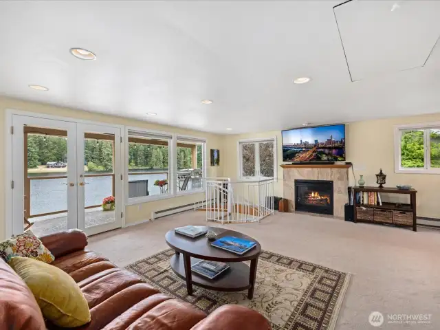 Large open Living Room with sweeping views of the lake, fireplace and Door out to Deck #1 for enjoying the outdoors 12 months a year.