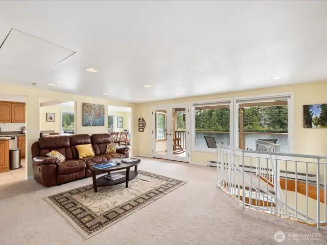 Large open Living Room with sweeping views of the lake, fireplace and Door out to Deck #1 for enjoying the outdoors 12 months a year.