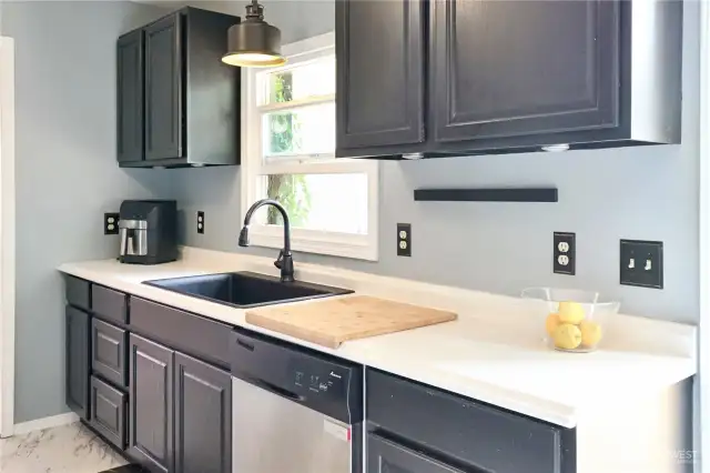 Deep chef-style sink with professional faucet adds practicality and polish to the kitchen  workspace.