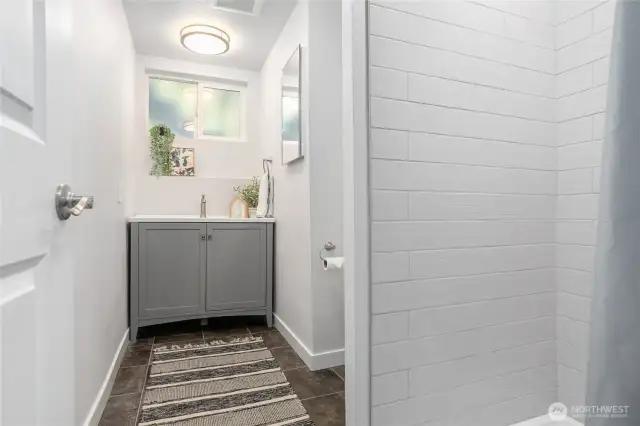 Fully updated 3/4 bath on lower level w/new vinyl flooring, tile shower, vanity & lighting