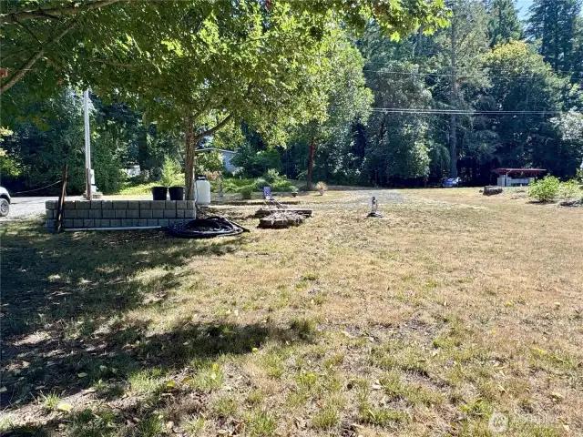 From the rear of the lot, the circular drive, parking pad, propane tank, and water source are visible.