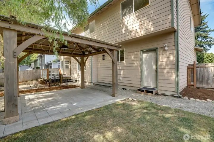 Fully fenced backyard offers a blend of open lawn, patio, and deck with easy access to the attached two car garage.