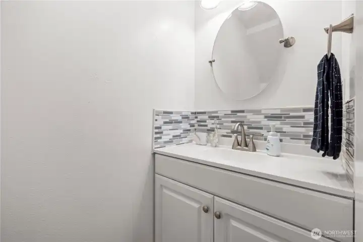 The first-floor bathroom is conveniently located for guests, complete with updated cabinets and countertops. Easy access from the main level makes it both practical and stylish.