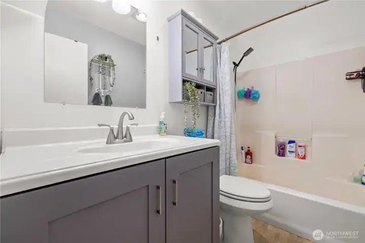 The primary bathroom features its own full bathroom with a shower, sink, and toilet. Updated cabinets and great lighting give the space a fresh and comfortable feel.