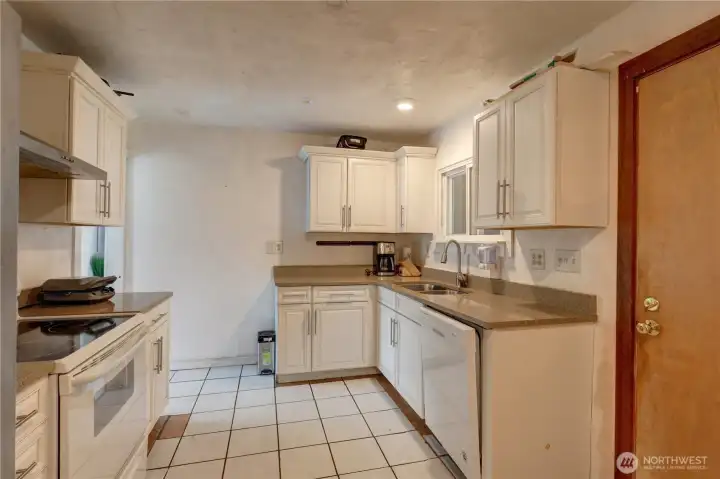 Kitchen with tile floors and solid surface counters