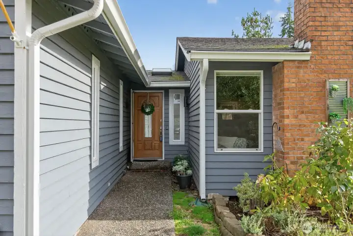 Entry way with concrete walk way leads you in. Home has wood siding.
