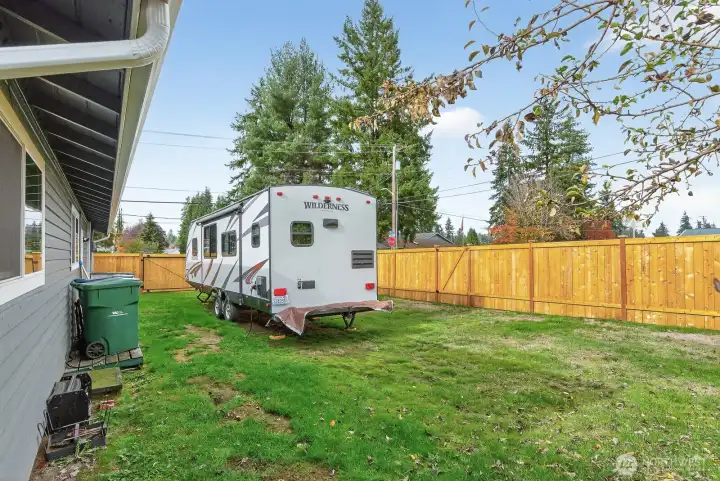 Side yard that has a new fence from Summer of 2025. Big RV gate and water & power hook ups for the RV. New generator hook up and housing box 2024.