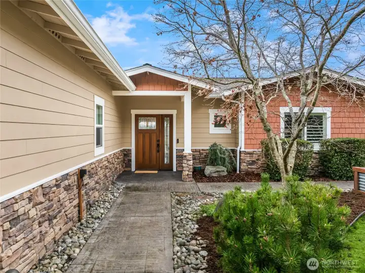 A craftsman-style front door with hinged sidelight welcomes you home.
